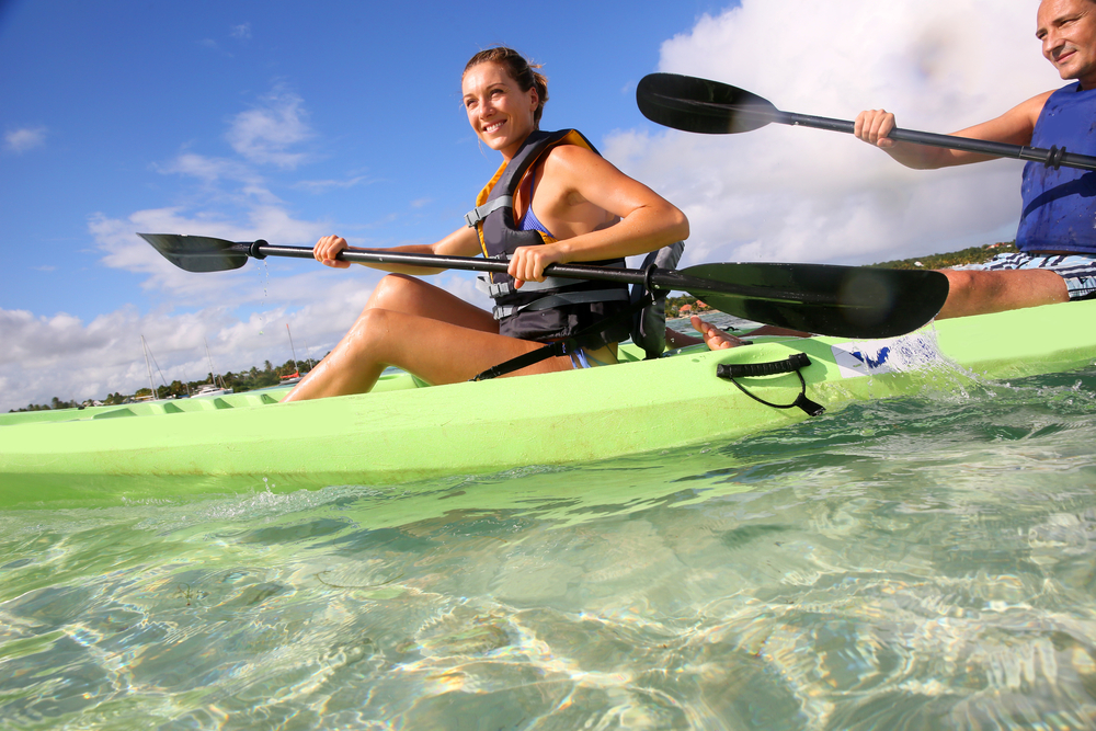 Couple canoeing in lagoon of West French indies Couple canoeing in lagoon of West French indies